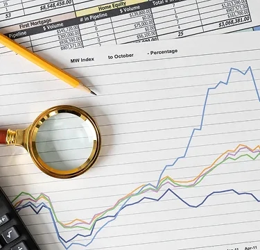 Gráficos de desempenho financeiro analisados com lupa, representando análise econômica e tomada de decisão em investimentos